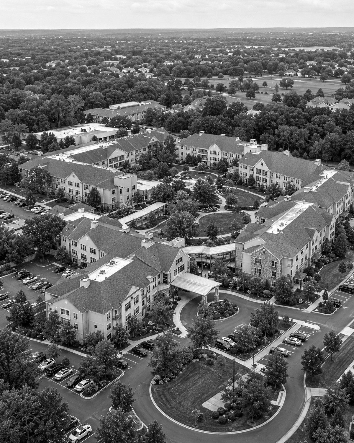 Aerial view of a continuing care campus with residential buildings around a landscaped courtyard